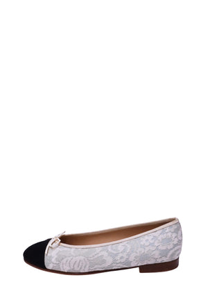 Chanel ivory floral lace ballet flat featuring intricate embroidered floral detailing, contrasting black cap toe, delicate ivory bow, matching trim, and low stacked heel