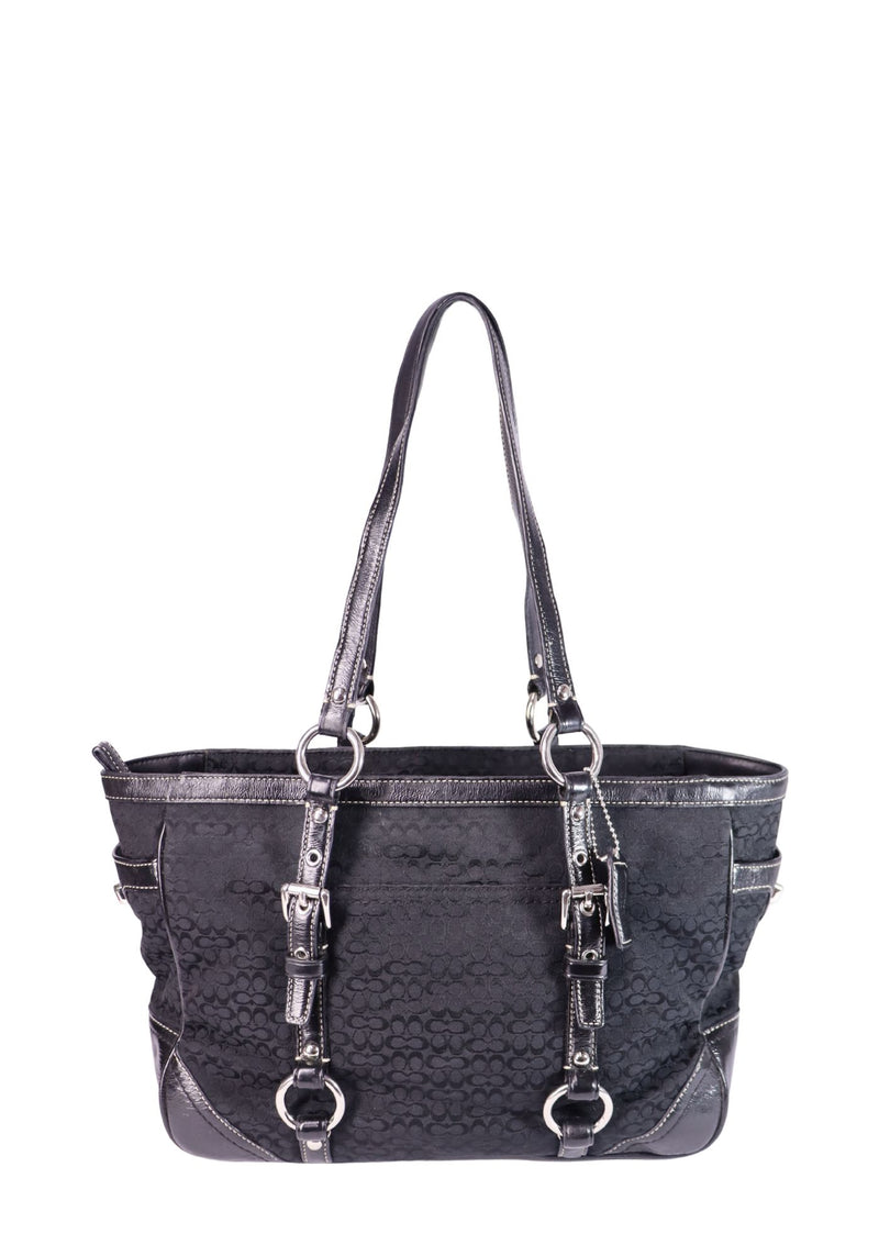 Coach black signature jacquard tote bag with silver-tone hardware, leather trim, and shoulder straps.