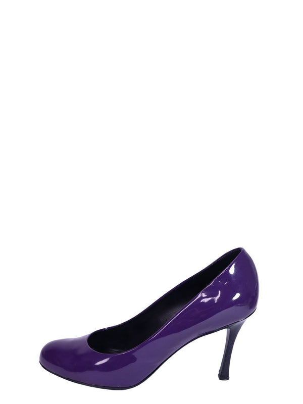 Saint Laurent purple patent leather pumps with round toe silhouette, glossy finish, and elegant curved mid-height heels.